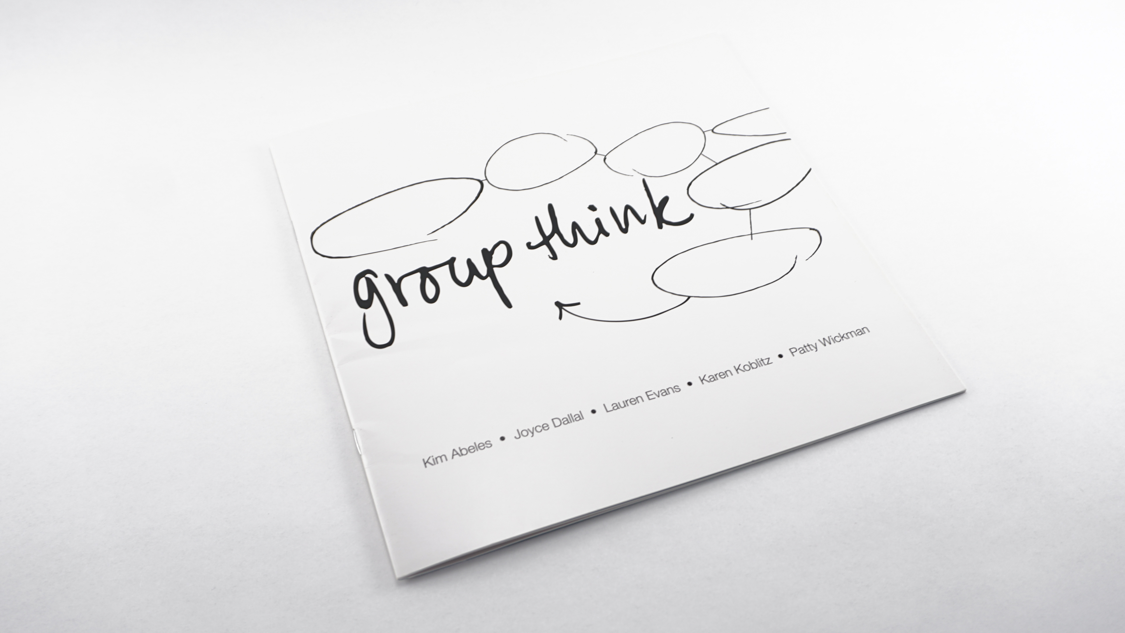 Cover of a book with black, hand-drawn text that reads "Group Think" on a white background. The text is surrounded by thought bubbles. Designed by Alexa Lasco.