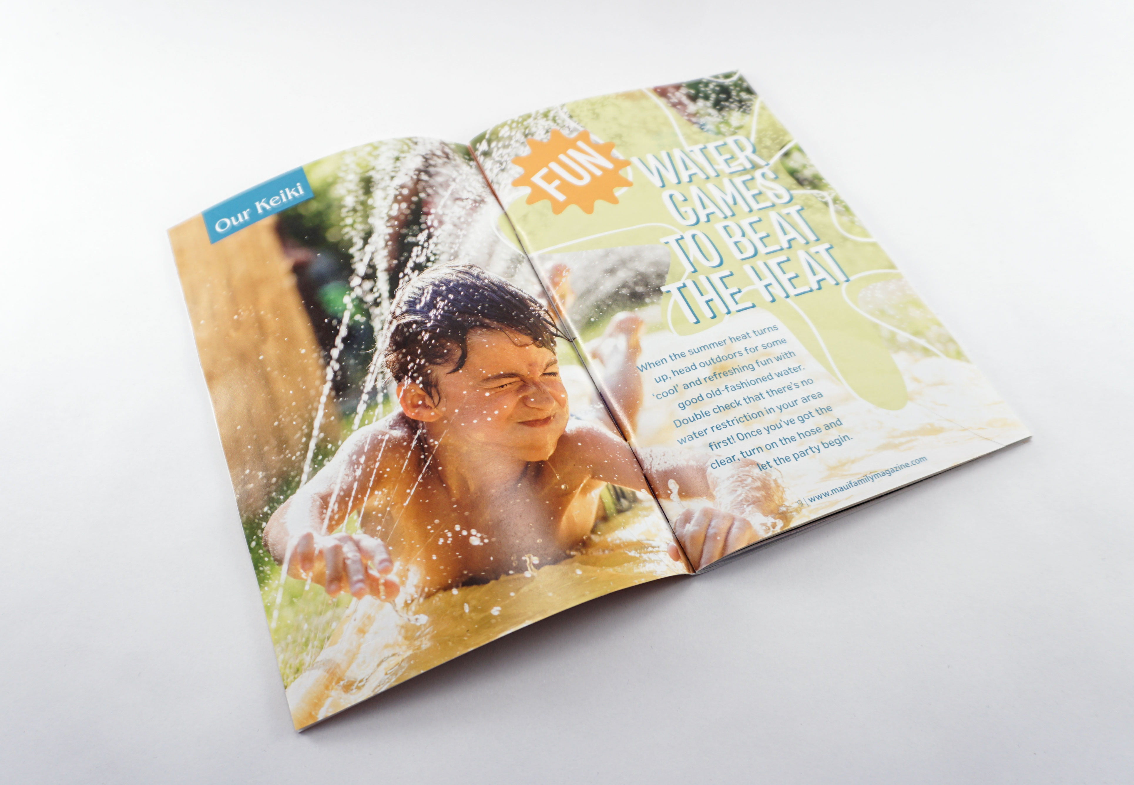 A magazine spread with a boy getting splashed while coming down a water slide. The article title reads "Fun Water Games to Beat the Heat", designed by Alexa Lasco.